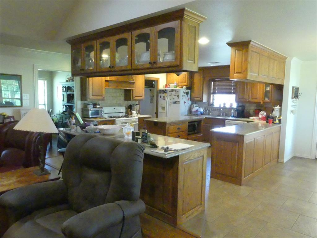 3421 Schoolhouse Road Forestburg, TX 76239 - Photo 6 of 39 a kitchen with stainless steel appliances granite countertop a stove a sink and a refrigerator
