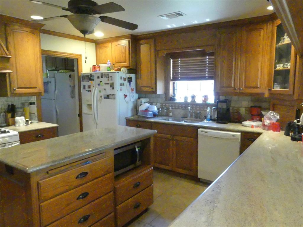 3421 Schoolhouse Road Forestburg, TX 76239 - Photo 7 of 39 a kitchen with cabinets and window
