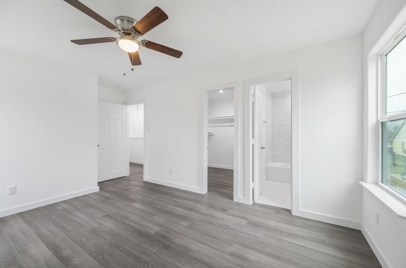 an empty room with wooden floor and windows
