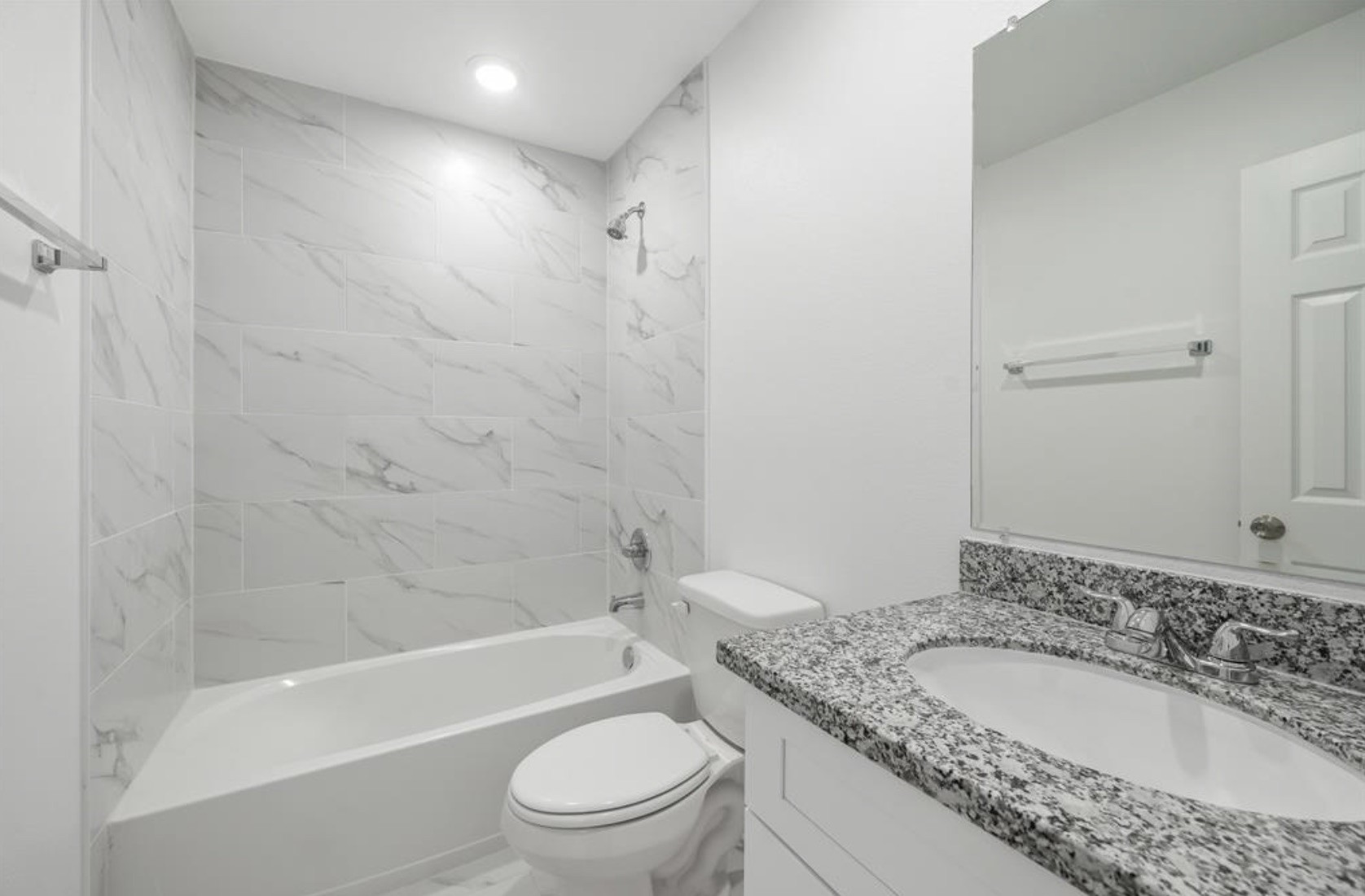 7804 Crestview Drive, Unit B Houston, TX 77028 - Photo 16 of 18 a bathroom with a granite countertop toilet a sink and a bathtub