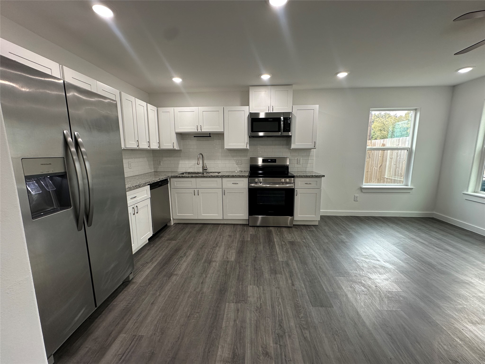 7804 Crestview Drive, Unit B Houston, TX 77028 - Photo 4 of 18 a kitchen with stainless steel appliances a refrigerator a sink dishwasher a stove and white cabinets with wooden floor