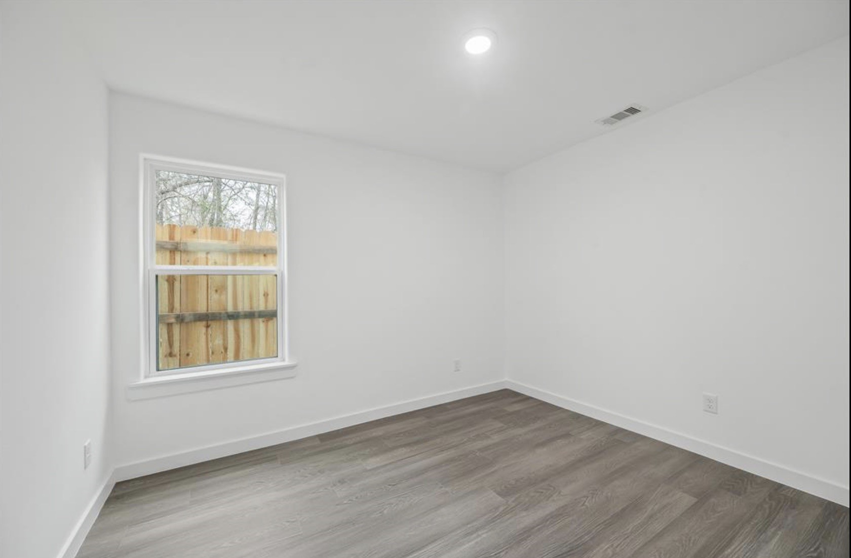 7804 Crestview Drive, Unit B Houston, TX 77028 - Photo 9 of 18 an empty room with wooden floor and windows
