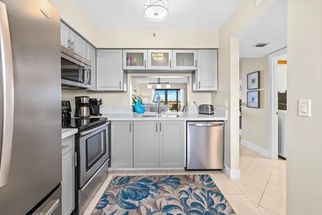 a kitchen with stainless steel appliances granite countertop a refrigerator sink and stove