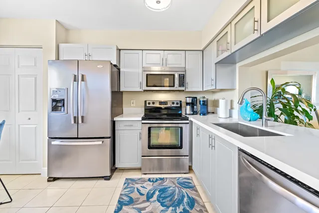 a kitchen with granite countertop a refrigerator stove and microwave