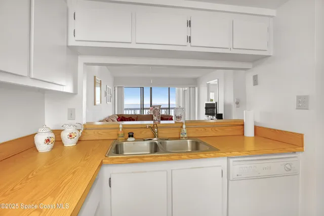 a view of a kitchen with kitchen island a sink and a refrigerator