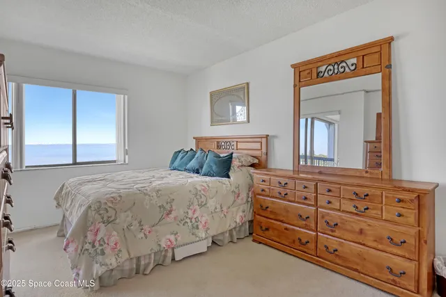 a bedroom with a bed and a mirror on dresser