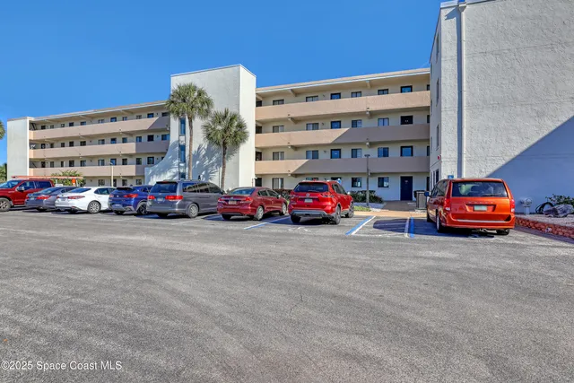 a tall buildings with cars parked in front of it