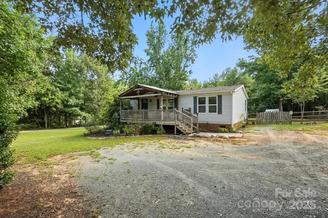 a view of a house with backyard and trees