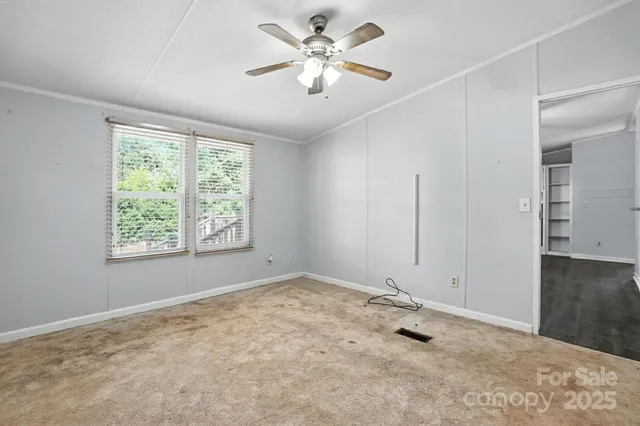a view of a big room with windows and chandelier fan
