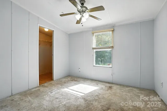 a view of a big room with windows and chandelier fan