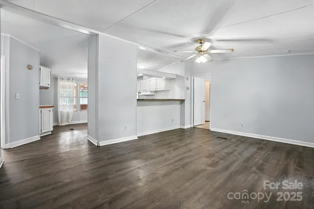 wooden floor in an empty room with a kitchen