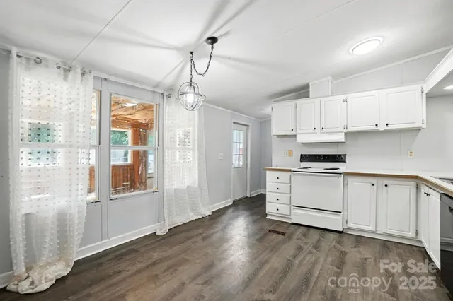 a kitchen with stainless steel appliances a white cabinets and wooden floor