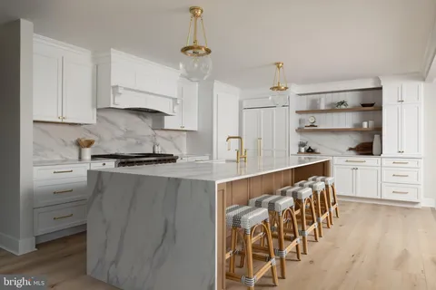 a kitchen with white cabinets and appliances