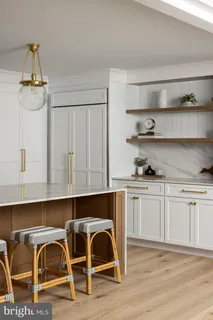 a kitchen with stainless steel appliances granite countertop a table chairs in it and wooden floors