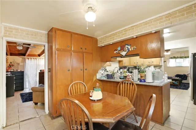 a dining room filled chandelier and kitchen view