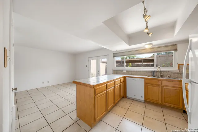 a kitchen with a stove a sink dishwasher and a refrigerator