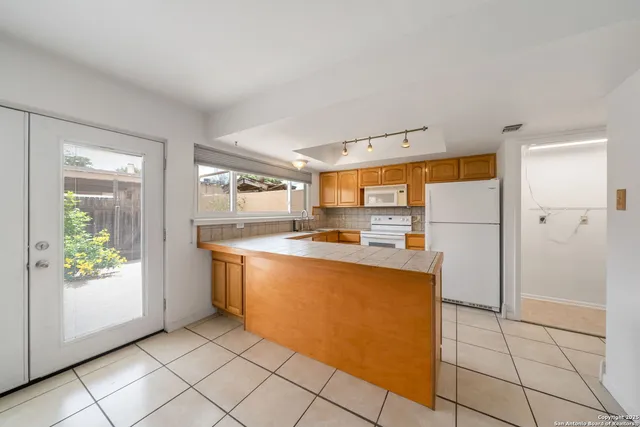 a kitchen with stainless steel appliances granite countertop a refrigerator and a stove
