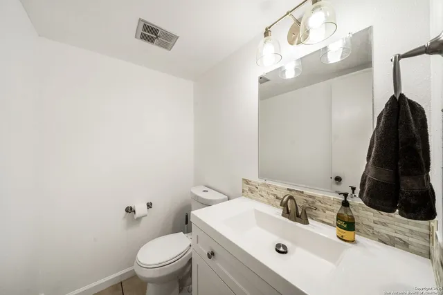 a bathroom with a sink toilet and mirror