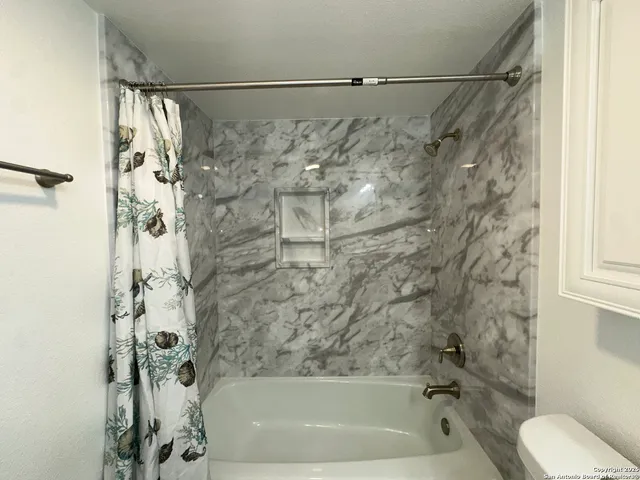 a bathroom with a shower and a bath tub