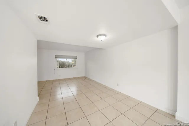 an empty room with white walls and windows