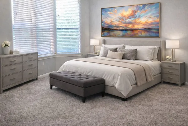 a spacious bedroom with a bed and a painting on the wall