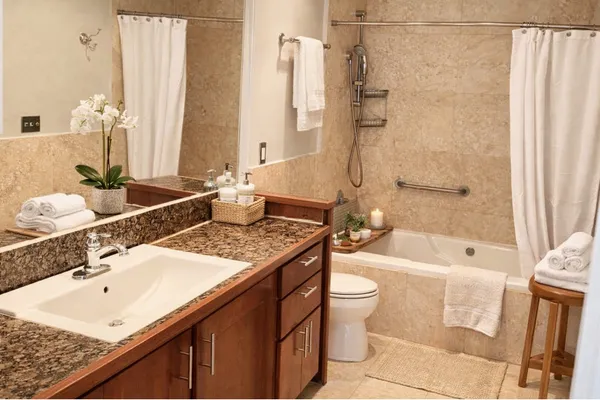 a bathroom with a granite countertop sink toilet and shower