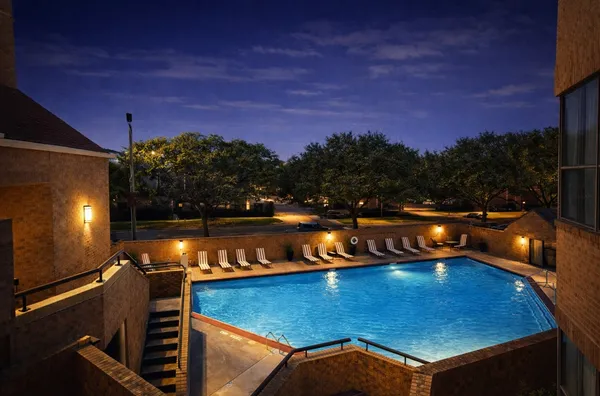 a view of a swimming pool with a patio and a yard