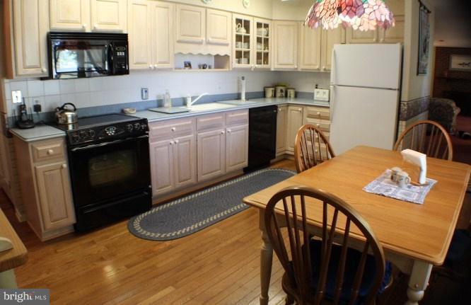 204 Thompson Road Chester, MD 21619 - Photo 23 of 30 a kitchen with stainless steel appliances granite countertop a stove a sink dishwasher a microwave oven with a dining table and chairs