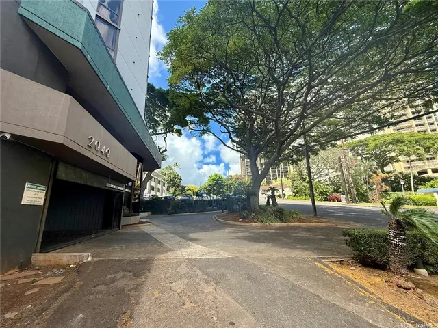 a view of a street with a building and trees