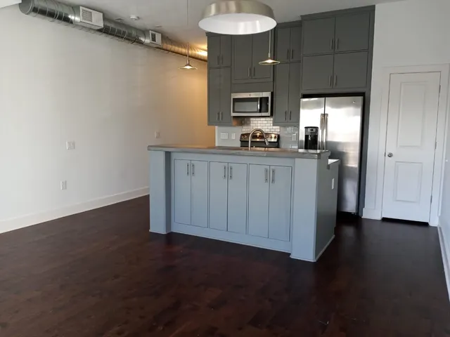 a kitchen with granite countertop a sink cabinets and a wooden floor