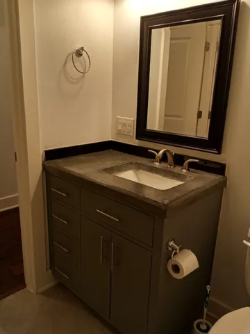 a bathroom with a granite countertop sink and mirror