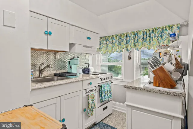 a kitchen with a stove and a white cabinets