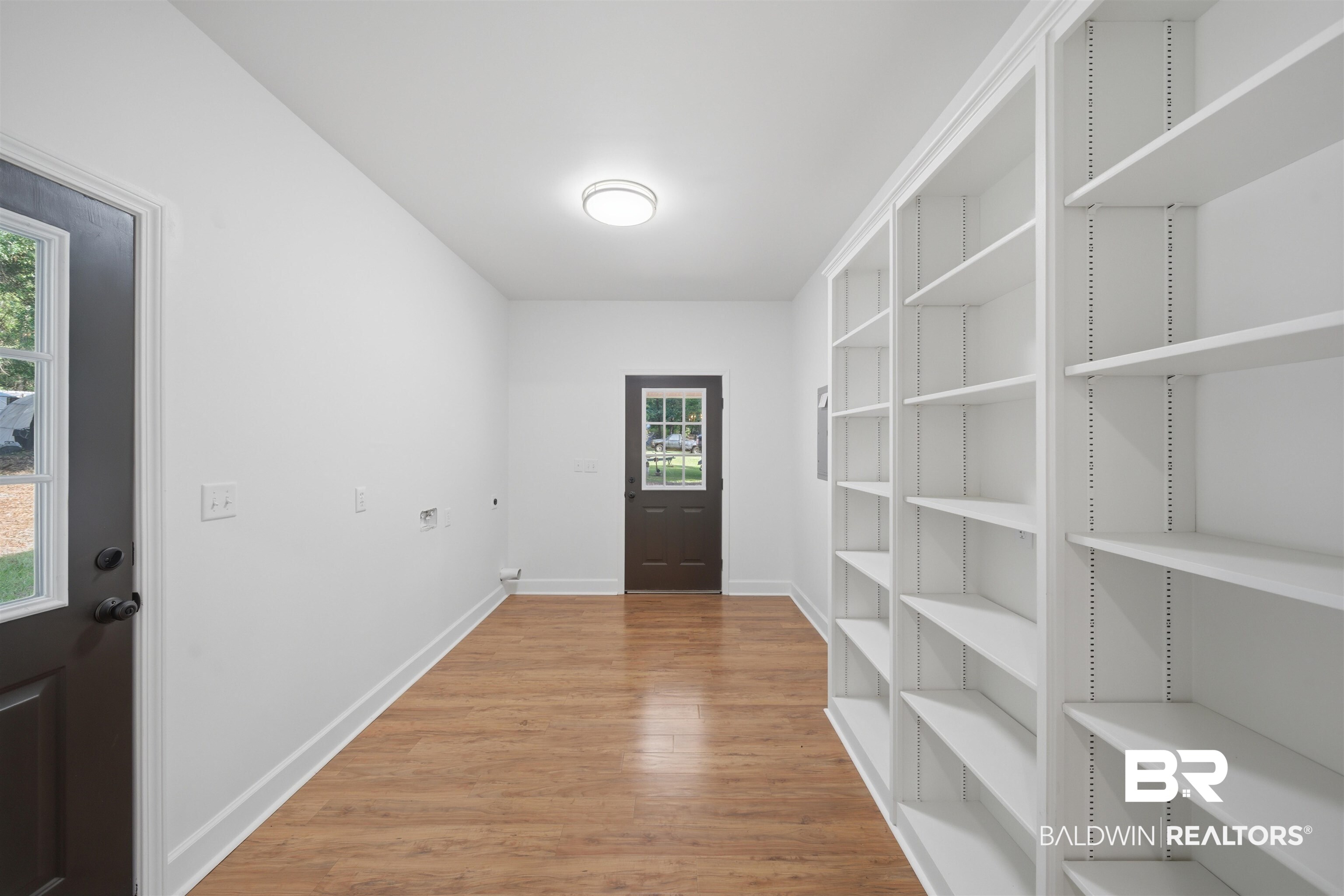 14128 Jackson Lane Foley, AL 36535 - Photo 14 of 36 Spacious utility room featuring extensive built-in shelving, durable wood-finish flooring, and recessed lighting