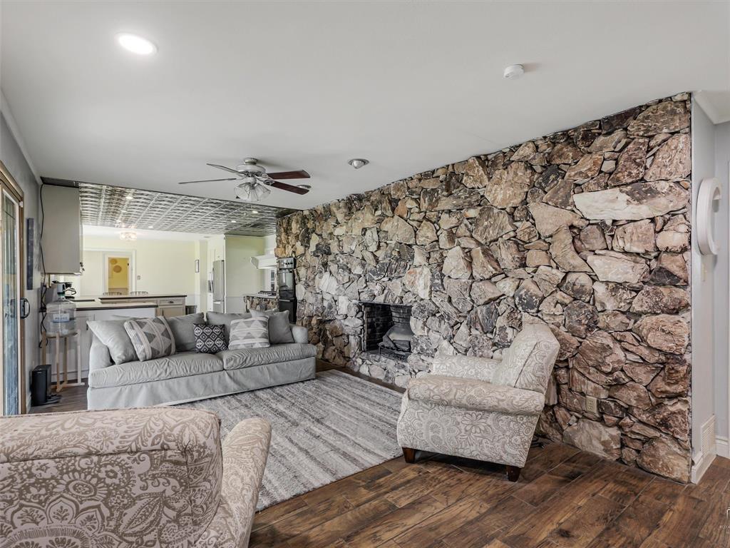 62 Sanders Road Whitesboro, TX 76273 - Photo 9 of 19 A spacious secondary living area is anchored by a dramatic floor-to-ceiling stone fireplace, creating a warm and inviting focal point.