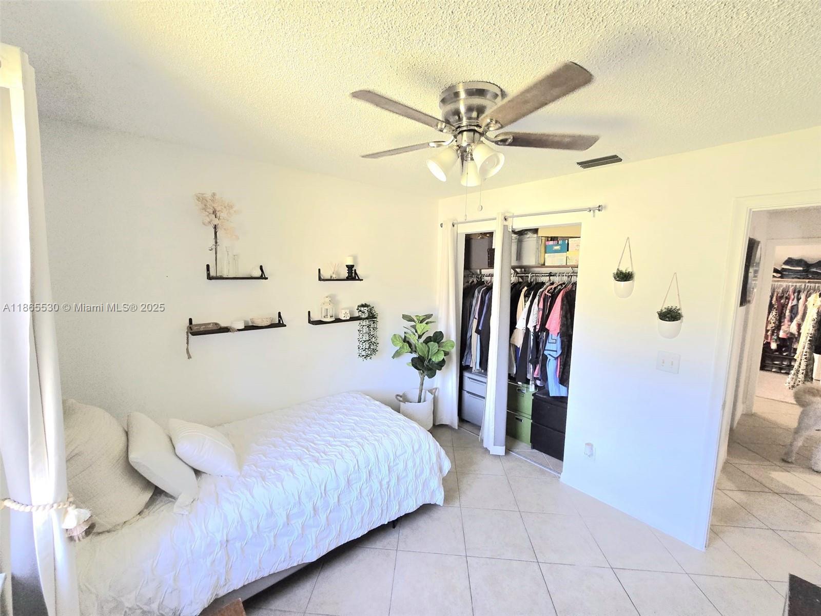 6120 Edwards Road Margate, FL 33063 - Photo 19 of 47 a bedroom with a large bed and a ceiling fan