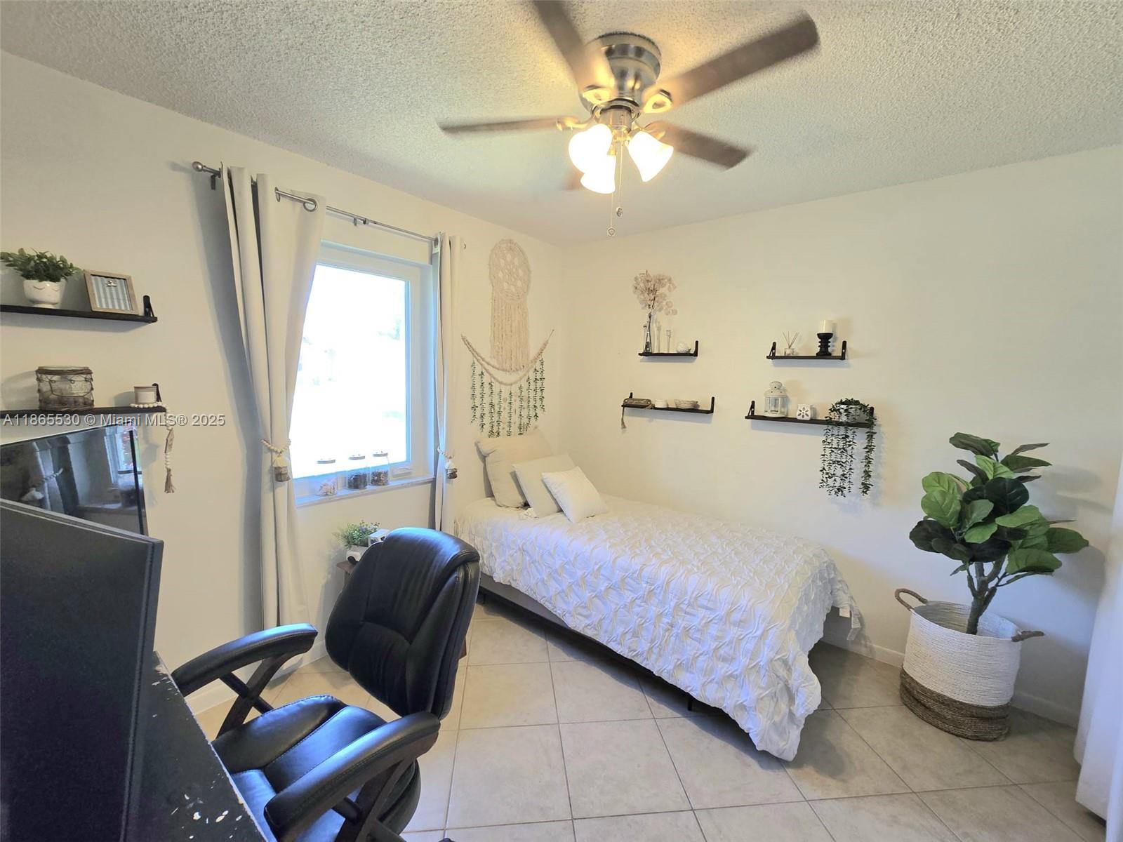 6120 Edwards Road Margate, FL 33063 - Photo 20 of 47 a bedroom with a bed chair and a potted plant