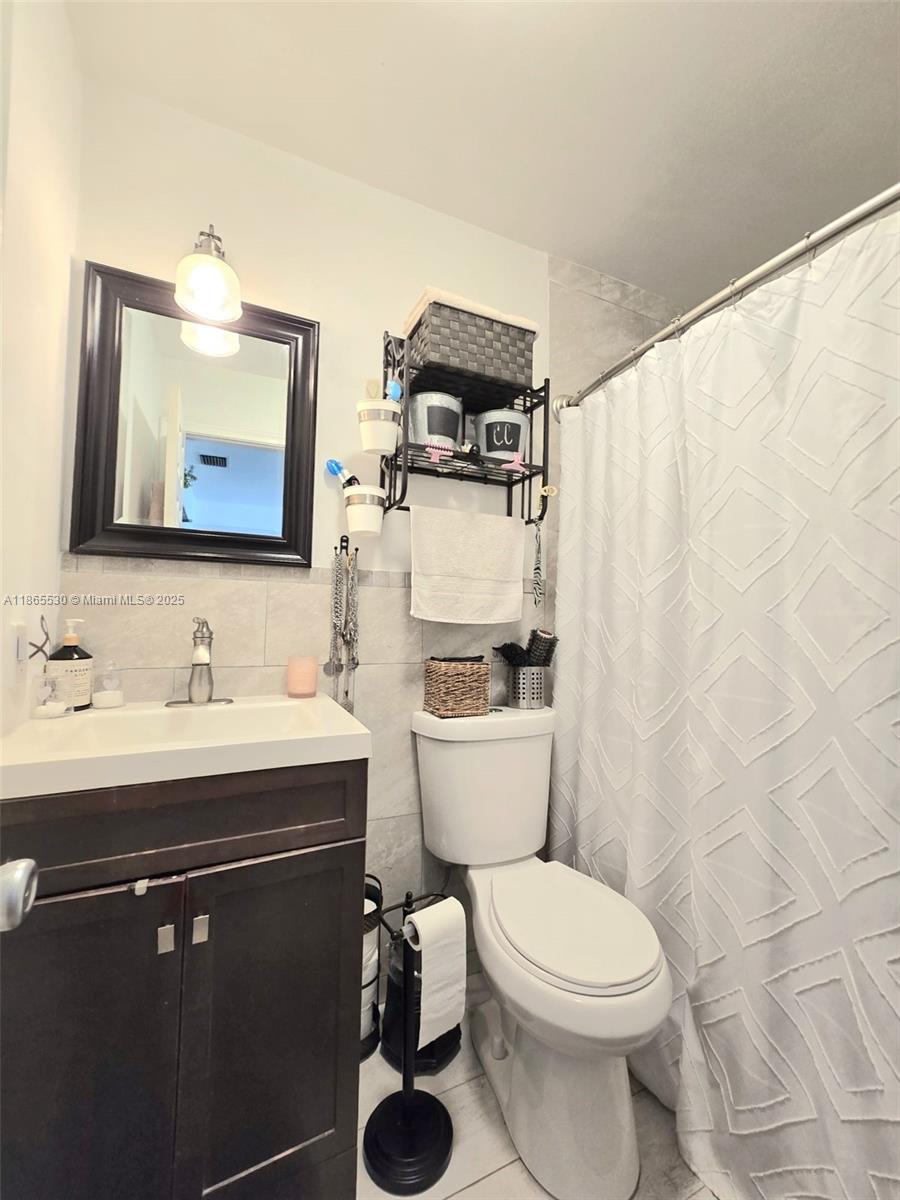 6120 Edwards Road Margate, FL 33063 - Photo 22 of 47 a bathroom with a toilet sink and mirror