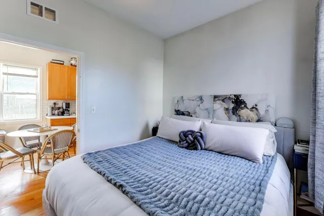 a bedroom with a bed and wooden floor