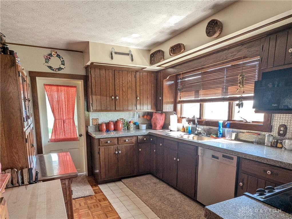 8713 Oakes Road Arcanum, OH 45304 - Photo 14 of 29 This cozy kitchen features abundant wood cabinetry, granite countertops, and natural light.