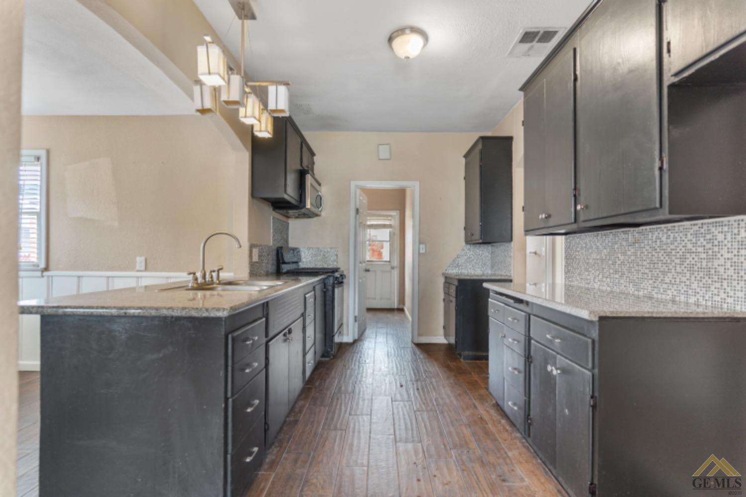 Undisclosed Address Taft, CA 93268 - Photo 14 of 17 a kitchen with stainless steel appliances granite countertop a sink a stove and a wooden floors
