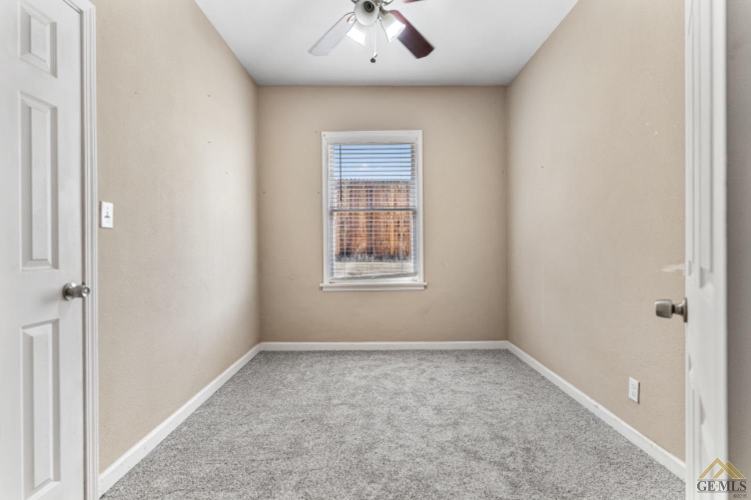 Undisclosed Address Taft, CA 93268 - Photo 3 of 17 an empty room with a window and a chandelier fan