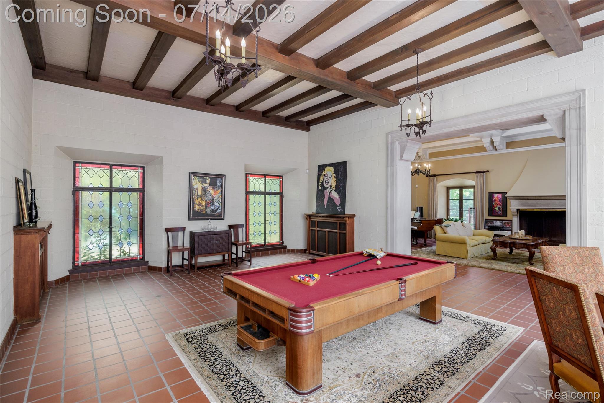 189 Cloverly Road Grosse Pointe, MI 48236 - Photo 11 of 96 Spacious room featuring exposed wood ceiling beams, terra cotta floor tiles, and multiple stained-glass windows