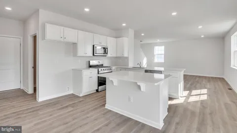 a kitchen with stainless steel appliances granite countertop a sink and a refrigerator