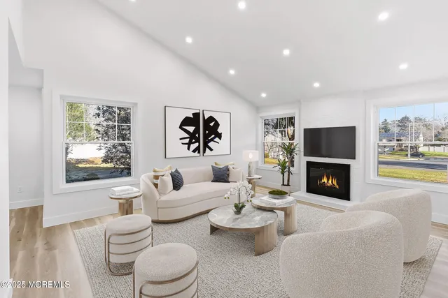 a living room with furniture a fireplace and a large window