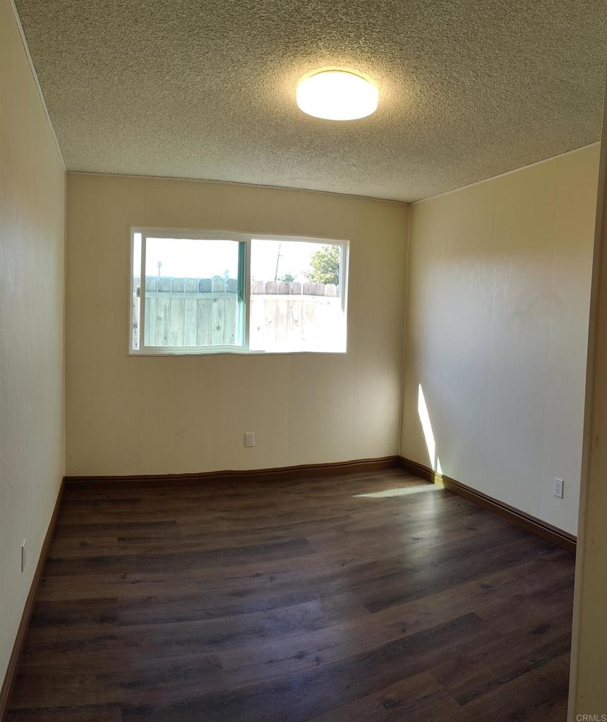 5382 Bonita Drive San Diego, CA 92114 - Photo 4 of 15 an empty room with wooden floor and windows