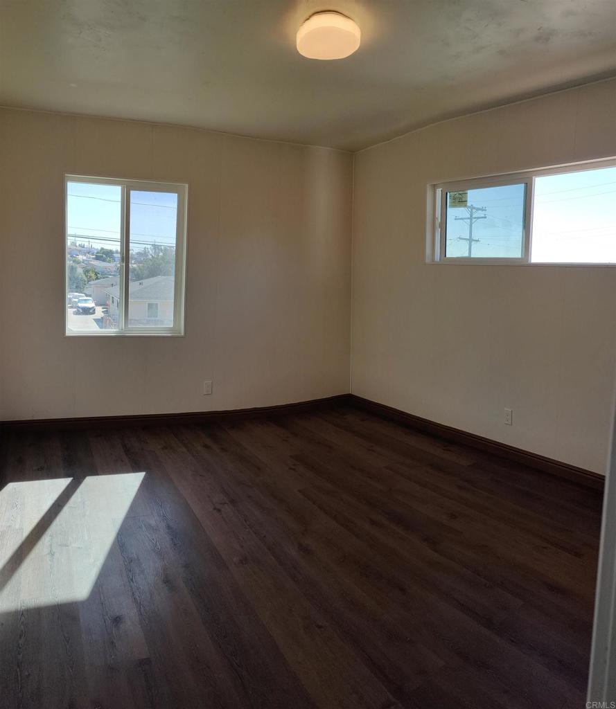 5382 Bonita Drive San Diego, CA 92114 - Photo 5 of 15 a view of an empty room with wooden floor and a window