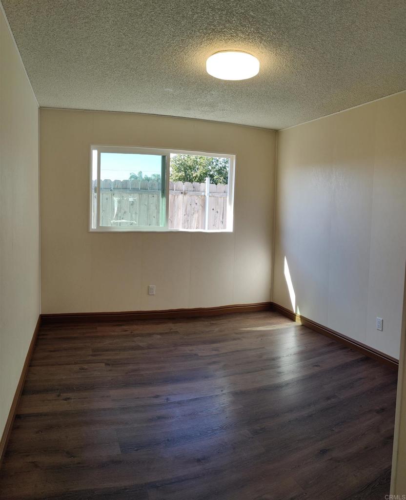 5382 Bonita Drive San Diego, CA 92114 - Photo 6 of 15 an empty room with wooden floor and windows