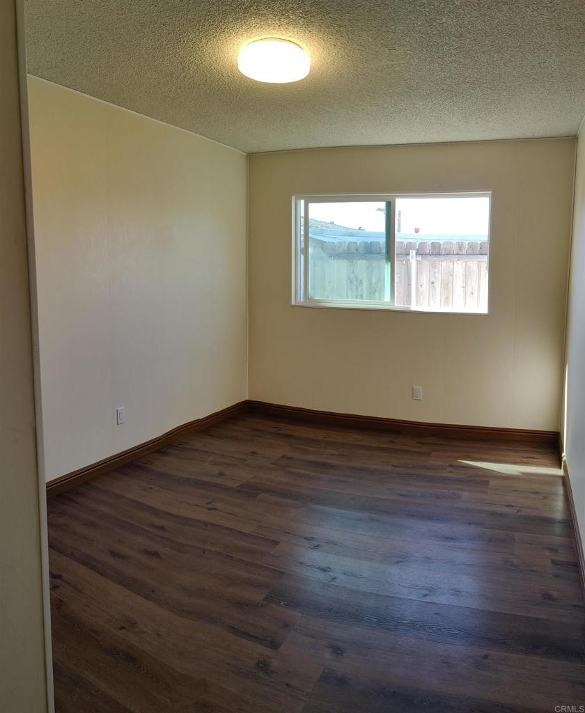 5382 Bonita Drive San Diego, CA 92114 - Photo 8 of 15 a view of an empty room with wooden floor and a window