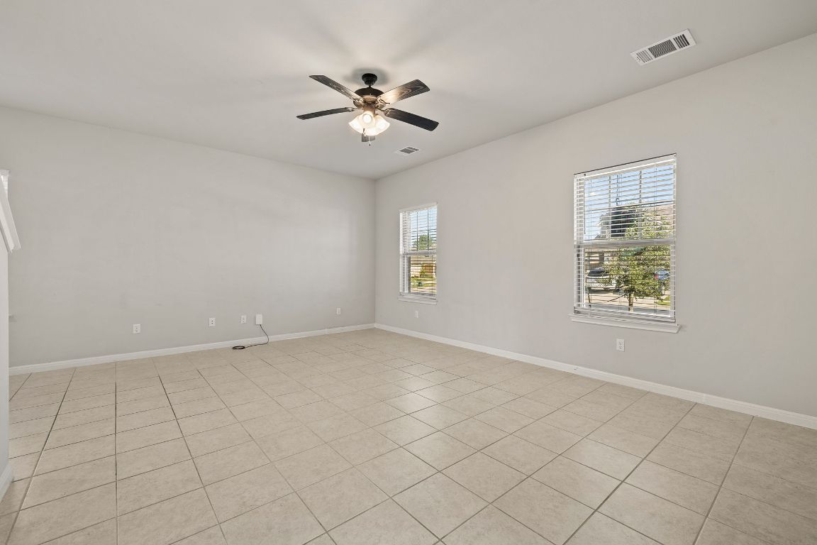 321 Arabian Colt Drive Georgetown, TX 78626 - Photo 4 of 24 an empty room with chandelier fan and windows