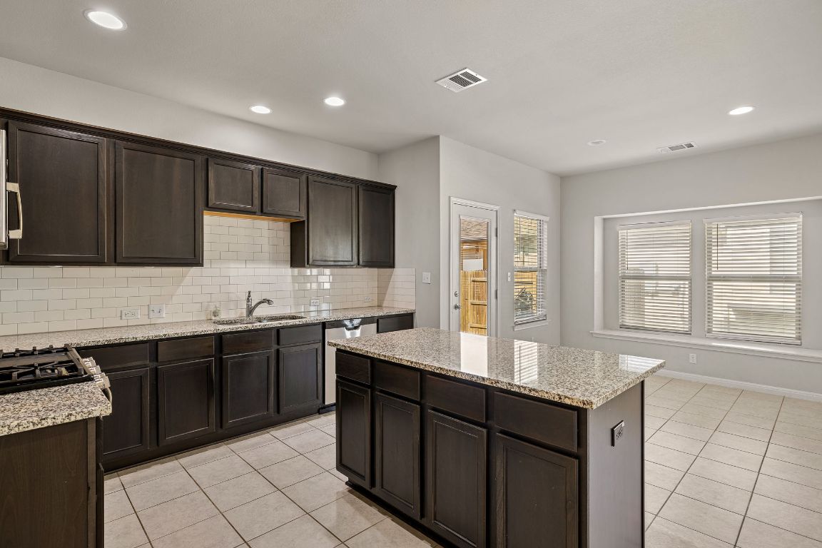 321 Arabian Colt Drive Georgetown, TX 78626 - Photo 9 of 24 a kitchen with granite countertop a sink stove and cabinets